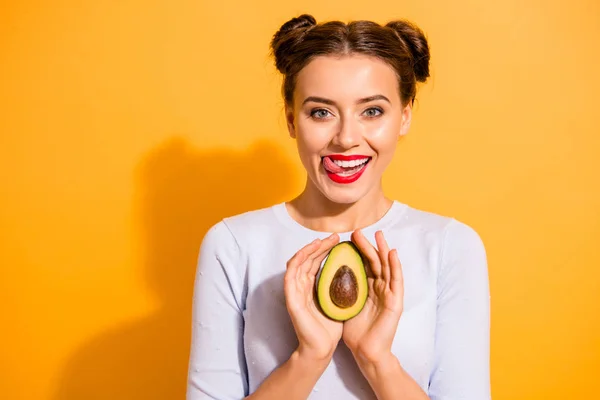 Close up photo beautiful she her her lady pretty hairdo hold slice avocado tongue out mouth want taste try eat plant lick upper lip wear casual white sulover clothes isolated yellow background —  Fotos de Stock