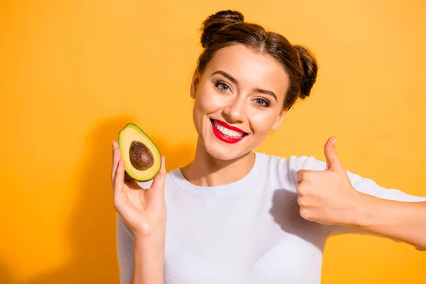 Close up photo beautiful she her her lady pretty hairdo hold slice avocado show thumb up advising use user buy buyer new oil extract cream wear casual white sulover clothes isolated yellow background —  Fotos de Stock