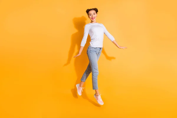 Full längd kroppsstorlek foto av bedårande rolig student Walking Promenade nöjda bär vit bomull Pullover denim kläder rosa sneakers på färgglada bakgrund — Stockfoto