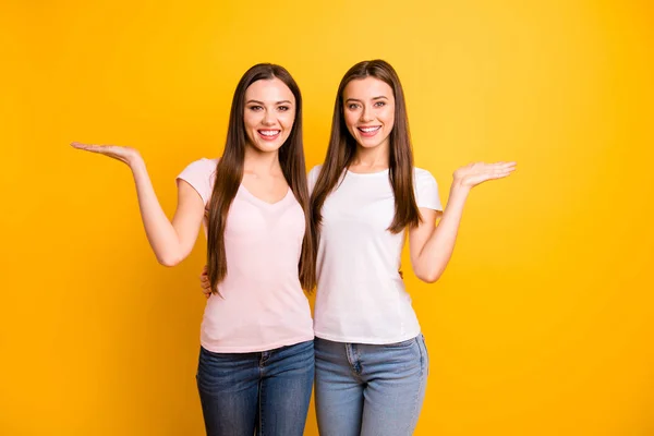 Fechar foto duas pessoas bonitas ela suas senhoras modelos melhores amigos mão braço palmas abertas indicam espaço vazio preto sexta-feira oportunidade desgaste branco rosa casual t-shirts isolado fundo amarelo — Fotografia de Stock