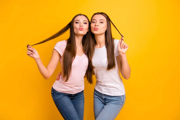 Close-up foto twee mensen mooi ze haar damesmodellen sturen lucht kusjes spelen krullen kronkelende vingers romantisch humeur knuffelen stand sluiten slijtage wit roze casual t-shirts geïsoleerd gele achtergrond — Stockfoto