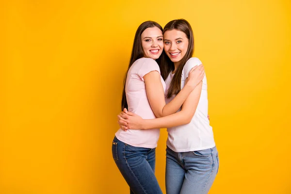 Zavřít postranní profil dva lidé jsou krásní její dámy modeluje plné emoce pocity nejlepší kamarádi stáže huggování stát blízko nosit bílé růžové neformální trička izolované žluté pozadí — Stock fotografie
