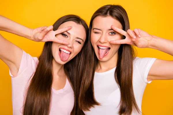 Nahaufnahme Foto von niedlichen lustigen hübschen Mädchen trendige Studenten am besten haben Freizeit Reisen machen V-Zeichen in Augennähe Zunge-out fühlen sich zufrieden sorglos isoliert tragen helle T-Shirts gelben Hintergrund — Stockfoto