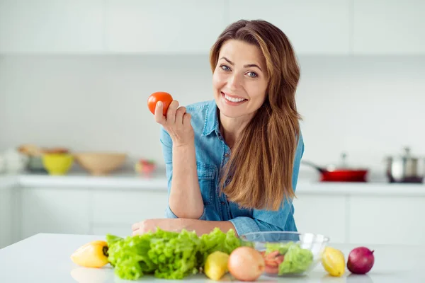 Portrait of her she nice lovely charming cute attractive cheerful cheery glad positive brown-haired lady holding in hand tomato mix vegs in light white interior style kitchen — Stock Photo, Image