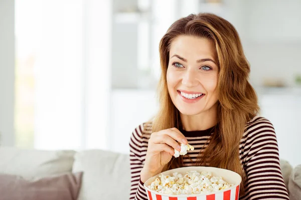 Close up photo beautiful she her model lady hands big container corns arms comic serial fast unhealthy food wear jeans striped pullover clothes sit comfort cosy divan house living room indoors — стоковое фото