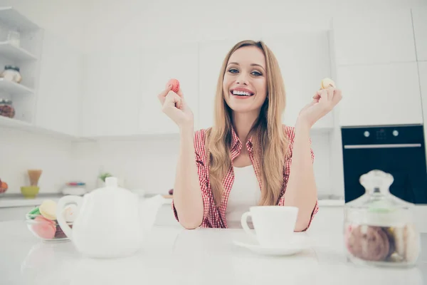 Close up foto retrato de alegre otimista positivo encantador encantador agradável agradável bonito adorável ela sua senhora segurando dois biscoitos amarelos ping em mãos sentadas à mesa — Fotografia de Stock