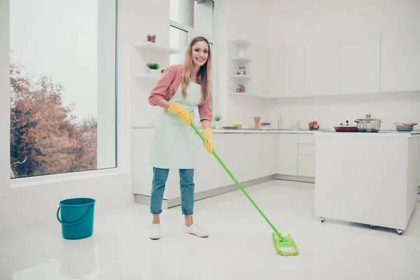 Longitud completa perfil lateral tamaño del cuerpo foto hermosa ocupado buenos deberes que su señora lavar el piso blanco con cuidado no se apresure ropa de camarera vaqueros vaqueros camisa casual cubierto delantal lindo luz brillante cocina —  Fotos de Stock