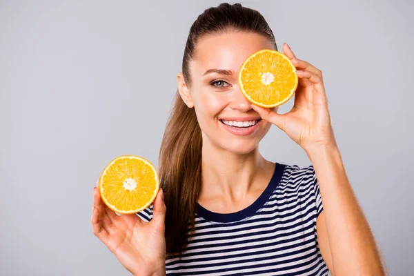 Close up foto bello incredibile lei la sua signora tenere le mani braccia grande grande due mezze fette arancione nascondere un occhio nuovo olio estratto lavare lozione usura blu bianco strisce t-shirt isolato grigio fondo — Foto Stock