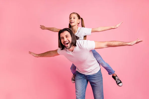 Close up photo beautiful she her little lady he him his daddy dad hold little princess piggyback hands arms like airplane rest relax wear casual white t-shirts denim jeans isolated pink background — Stock Photo, Image