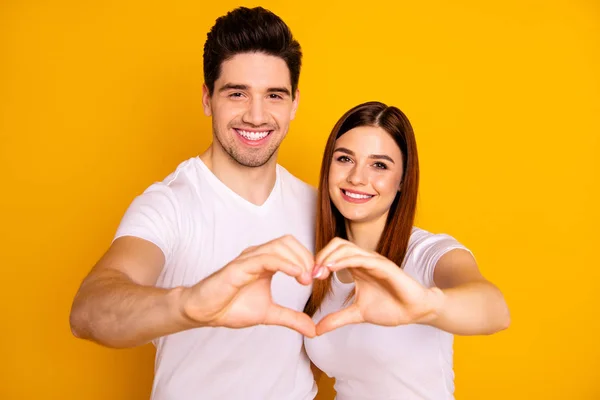Close up photo amazing beautiful she he he he he his guy lady hands arms fingers make heart figure form romance mood hugging sincere wear casual white t-shirts outfit isolated yellow background —  Fotos de Stock