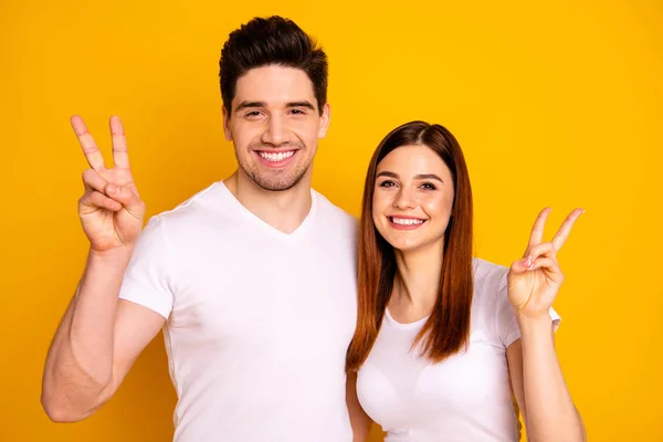 Close up foto engraçada incrível linda ela ele ele seu cara senhora mãos braços mostrar v-sinal dizer oi animar stand abraçando sincero radiante sorriso desgaste casual branco t-shirts roupa isolado fundo amarelo — Fotografia de Stock