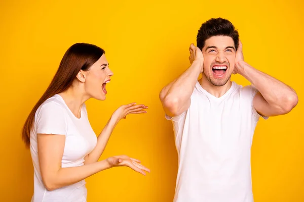 Close up side profile photo two beautiful people she her he he his blame yell fault aggression look up hide ears palms hands arms not listen wear casual white t-shirts isolated yellow background — Fotografia de Stock