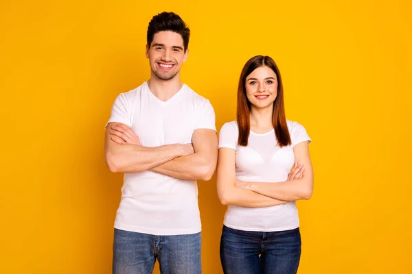 Close up photo beautiful cheer she her he him his pair stand side teamwork self-confident professionals specialists work job reliable workers wear casual white t-shirts isolated yellow background — Stock Photo, Image
