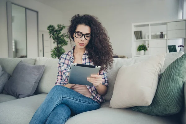 Ritratto di lei ha un bell'aspetto attraente bella dolce affascinante carino concentrata concentrata ragazza dai capelli ondulati seduta su divano lettura ebook in luce bianca sala interna — Foto Stock