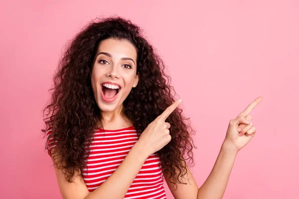 Primer plano retrato de ella ella agradable atractivo encantador adorable brillo alegre alegre alegre chica de pelo ondulado señalando a un lado aislado sobre rosa pastel fondo — Foto de Stock