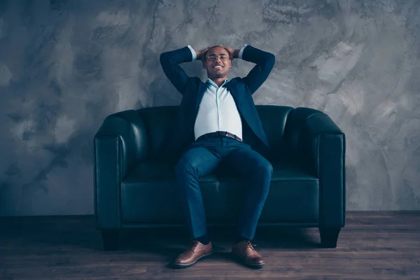 Portrait of his he nice stylish classy elegant attractive cheerful guy professional top company director banker sitting on couch having rest at workplace station gray concrete wall — Stock Photo, Image