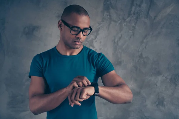 Portret van zijn hij mooie aantrekkelijke goed uitziende punctuele kerel draagt blauw t-shirt kijken naar Watch plan schema data bericht online geïsoleerd over grijze industriële betonnen muur — Stockfoto