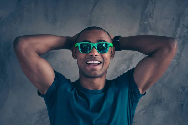 Close up photo amazing funky he he he he his dark skin macho hot modern look trend hold hands arms behind head great day mood weather excited wear specs casual blue t-shirt isolated grey background — Foto de Stock
