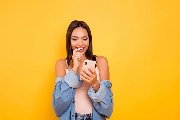 Närbild foto vacker hon hennes dam telefon händer armar bita munnen tänder index Fingerläsare nyheter rolig funky slitage casual pastell tank-top Jeans denim jacka isolerad gul ljus bakgrund — Stockfoto