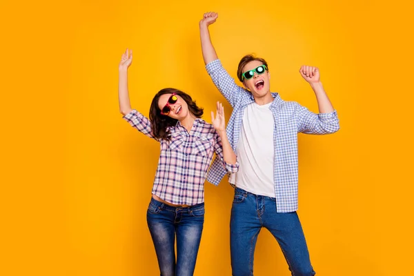 Close up foto de par em especificações de verão ele seu ela seu menino senhora mãos para cima dançando gritando alegria grande sorte pouco vestindo roupas casuais camisas xadrez isolado no fundo amarelo — Fotografia de Stock