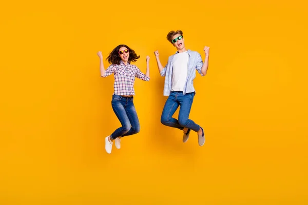 Close-up volledige lengte lichaam grootte foto van paar in de zomer specs hij hem zijn ze haar Lady jongen springen hoog in grootheid grappig gaan reizen dragen casual plaid shirt outfit geïsoleerd op gele achtergrond — Stockfoto