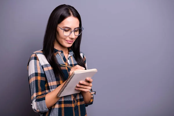 Retrato de atractiva encantadora gente joven lindo reflexivo tomar notas preparar informe de desgaste especificaciones vestido elegante camisa a cuadros de moda aislado fondo gris — Foto de Stock