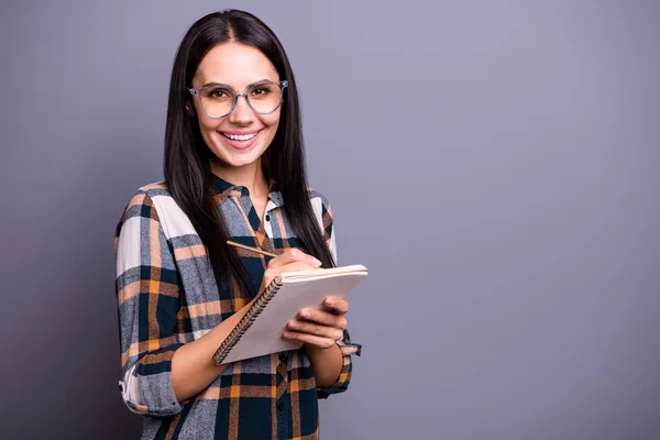 Retrato de atractivo encantador negocio mujer de negocios uso pluma plan de la mano tomar notas hacer informe aislado sentir contenido satisfecho sincero elegante camisa a cuadros aislado sobre fondo gris — Foto de Stock