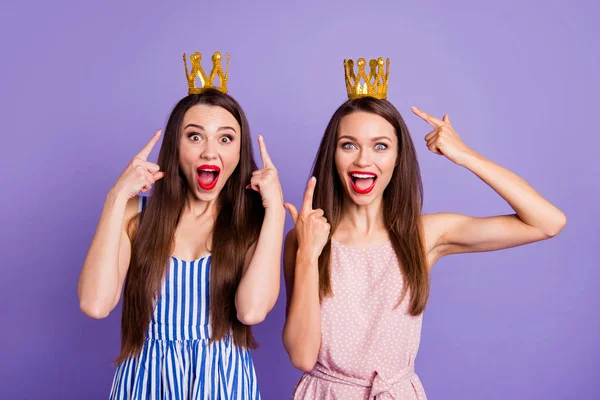 Close up portrait two people amazing beautiful she her models ladies indicate fingers power status gold crowns head look wear summer colorful dresses isolated purple violet bright background — Stock Photo, Image