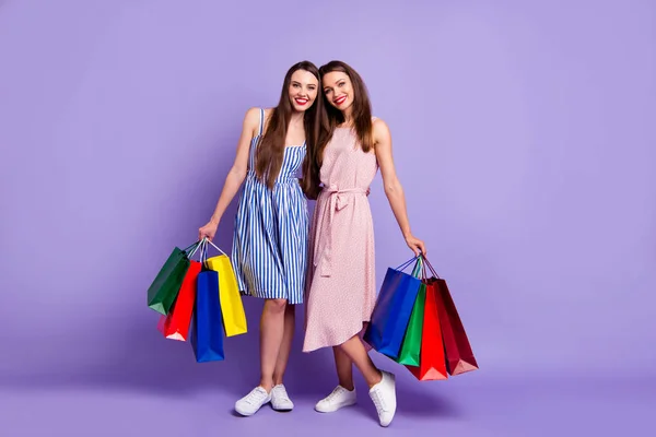 Ganzkörpergröße Foto zwei Personen schön sie ihre Modelle chic Damen tragen viele Packungen freundliche Stimmung Gemeinschaft tragen lässige Sommer bunte Kleider isoliert lila violett hellen Hintergrund — Stockfoto