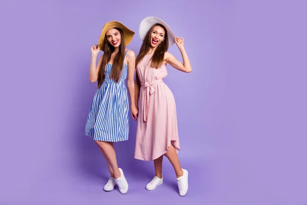 Ganzkörpergröße Foto zwei schöne funky sie ihre Modelle Damen halten Hände sonniges Wetter Strand Meer Küste Sonnenbaden tragen Sonnenhüte Sommerkleider isoliert lila violetten Hintergrund — Stockfoto