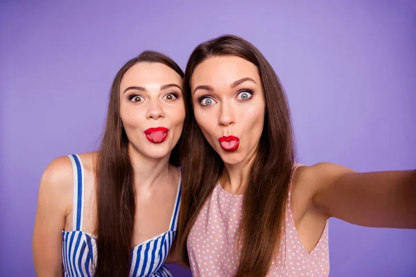 Close up φωτογραφία δύο άνθρωποι όμορφος/η παράξενο περίεργο αυτή μοντέλα της Chic κυρίες κάνουν να πάρει selfie των γλώσσα έξω από το στόμα σαχλαμαρίζεις κόκκινο κραγιόν φορούν καλοκαιρινά φορέματα απομονωμένη Μωβ μοβ φόντο — Φωτογραφία Αρχείου