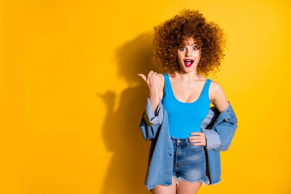 Portrait of her she nice cute lovely winsome fascinating charming attractive cheerful wondered stunned wavy-haired girl pointing aside ad advert isolated over bright vivid shine yellow background — Stock Photo, Image