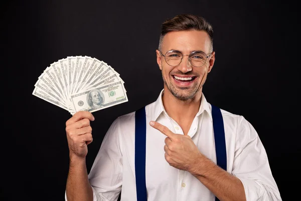 Close-up portret van mooie aantrekkelijke vrolijke kerel dragen brillen brillen tonen fan van USD 100 win Winner loterij krediet lening freelance spaardeposito Bank geïsoleerd op zwarte achtergrond — Stockfoto