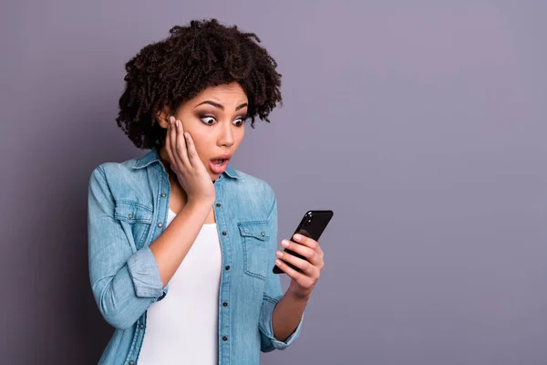 Retrato de asombrada reacción juvenil estupor grito grito obtener noticias increíble inesperada omg touch mano barbilla dispositivo de sujeción usar ropa vaquera moderna aislado fondo gris — Foto de Stock