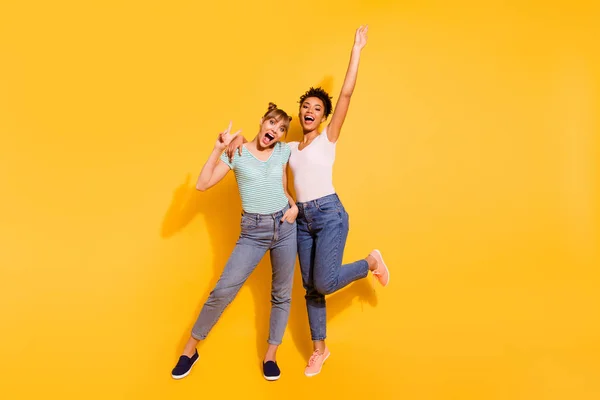 Full length body size photo beautiful she her lady laugh metal concert partdies fellows different nationalities hands raised wear casual white striped t-shirt isolated yellow bright background — стоковое фото