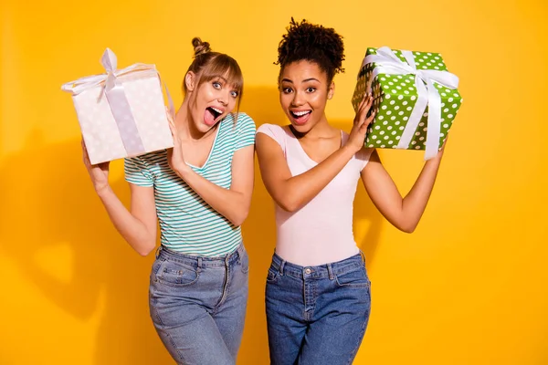 De cerca foto alegre estudiante de la mano gran presente aniversario grito contenido regocijarse sorprendido inesperada ondulado rizado corte de pelo top-nudo moño estilo de moda elegante camiseta jeans aislado fondo amarillo —  Fotos de Stock