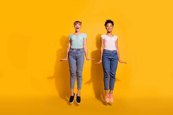 Full length body size view photo of cute excited funky youth hipsters summer enjoy fun laugh fellows fellowship wavy curly haircut jeans outfit trendy top knot style stylish isolated yellow background — Stock Photo, Image