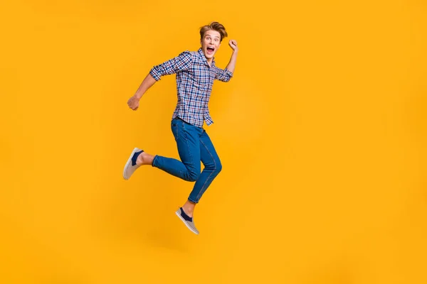 Ganzkörpergröße Ansicht Porträt von hübsch attraktiv fröhlich fröhlich optimistisch Kerl in kariertem Hemd Spaß beim Laufen schnell eilen Ansturm isoliert über hell lebendigen Glanz gelb Hintergrund — Stockfoto