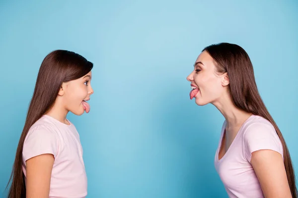 Close-up profile side view portrait of two nice attractive naughty cheerful cheery straight-haired girls having fun fooling isolated over bright vivid shine green blue turquoise background — Stock Photo, Image