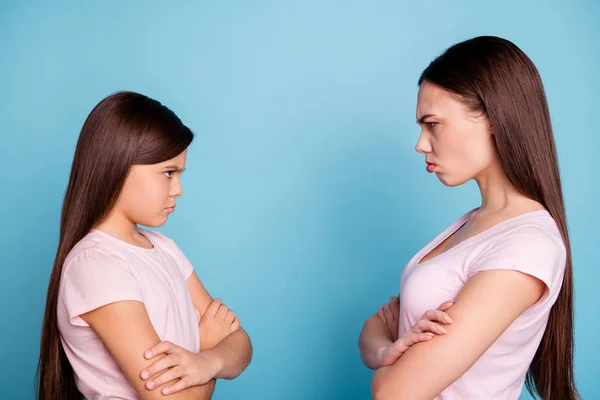 Close-up profile side view portrait of two attractive evil fury irritated annoyed displeased straight-haired girls disagree folded arms isolated over bright vivid shine green blue turquoise background — Stock Photo, Image