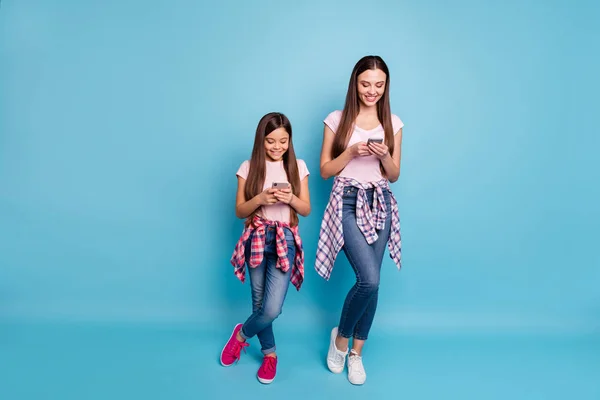 Longitud completa tamaño del cuerpo ver retrato de dos simpáticas encantadoras chicas alegres alegres alegres de pelo recto utilizando internet en línea tiempo libre aislado en brillante brillo vivo verde azul turquesa fondo —  Fotos de Stock