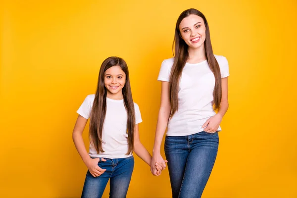 Close up photo two beautiful her she diversity lady different age best buddies hold hands arms go secondary highschool wear casual white t-shirts jeans denim clothes isolated yellow bright background — Stock Photo, Image