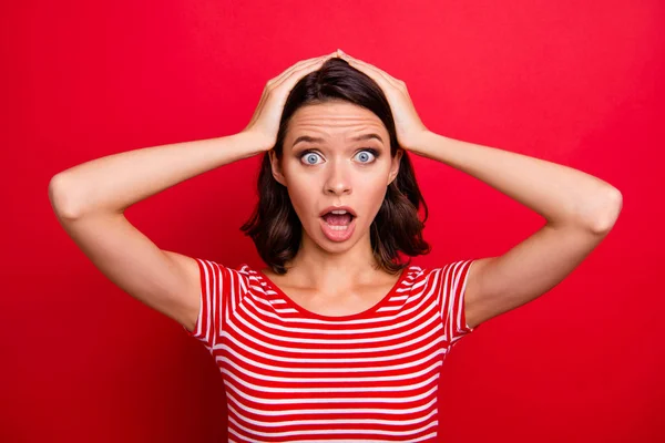 Portrait of disappointed horrified teen teenager astonished impressed wonder horrible terrible news novelty scream shout yell dressed modern clothing isolated bright red background touch hands head — Stock Photo, Image