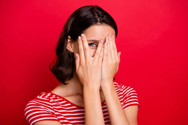 Close up photo of pretty nice charming teenager careless close hands face feel satisfied positive cheerful satisfied content enjoy dressed striped t-shirt isolated over red background — стоковое фото