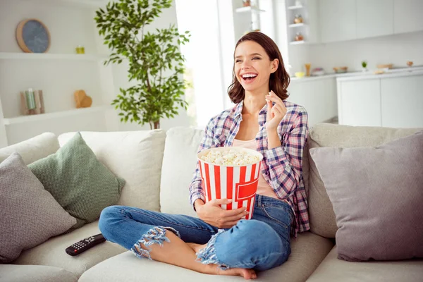 Poprtarit von niedlichen lustigen funky Dame sitzen Divan Beine gekreuzt gefaltet Lachinhalt fröhlich lustig funky Serien Sitcoms wellige lockige Frisur Hemd kariert karierte Jeans Wohnung — Stockfoto