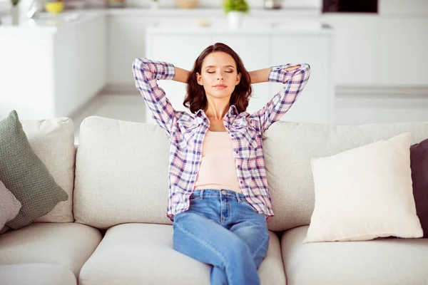 Close up photo amazing beautiful she her lady short hairdo eyes closed overjoyed hands arms behind head wear checkered plaid shirt jeans denim sit comfort divan house loft living room indoors — Stock Photo, Image