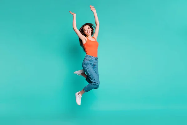 Full längd sidoprofil kroppsstorlek foto vacker hennes hon Lady Jump hög förvånad upphetsad lättsam helg semester slitage casual orange tank-top Jeans denim isolerad ljus Teal turkos bakgrund — Stockfoto