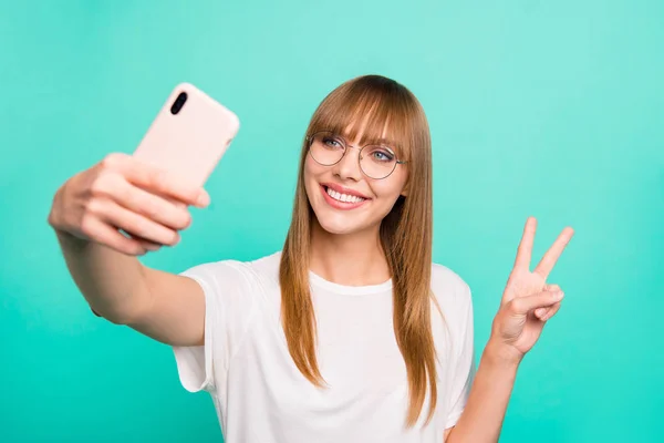 Close up photo amazing beautiful she her lady hand hold telephone make take selfies v-sign symbol positive friendly speak tell skype wear specs casual white t-shirt isolated teal green background — стоковое фото