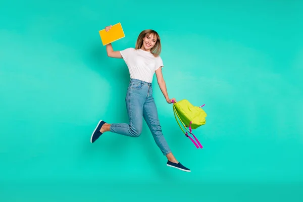 Comprimento total perfil lateral tamanho do corpo foto bonita ela sua senhora fim de semana saltar braços altos mãos segurar bloco notebooks no caminho para casa desgaste especificações jeans casual jeans branco t-shirt isolado fundo teal — Fotografia de Stock