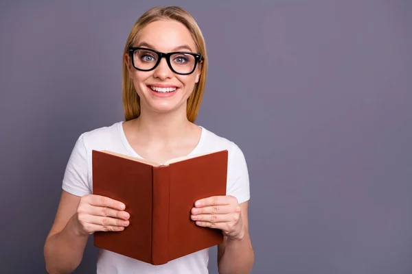 Portret van leuke schattige charmante tiener tiener inhoud tevreden vrolijke Hold hand gedrukte boek geïnteresseerd Imagine Dream dromerige hipster slijtage moderne t-shirt geïsoleerde grijze achtergrond — Stockfoto